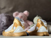 Rear view highlighting the white heel panels, gold collar overlays, and ankle graphics.