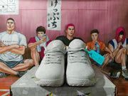 Front view of off-white Nike shoes with lace-up closure and perforated side panels.