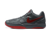 Side profile of a dark gray Jordan 12 sneaker with red side branding and a red outsole accent.