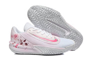 Side view of a white and pale pink Nike Precision 7 shoe beside its patterned outsole, with rose heel graphics.