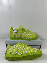 Green sneakers shown from the lateral and outsole angles, highlighting the oversized lettering and circular sole pattern.