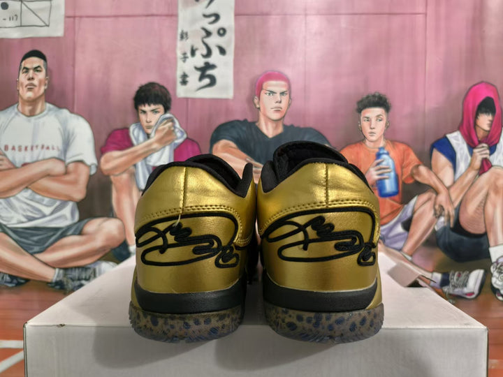 Rear view of metallic gold and black basketball shoes with spotted outsoles