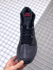 Top-down view of the black sneaker showing the perforated toe box and padded tongue.