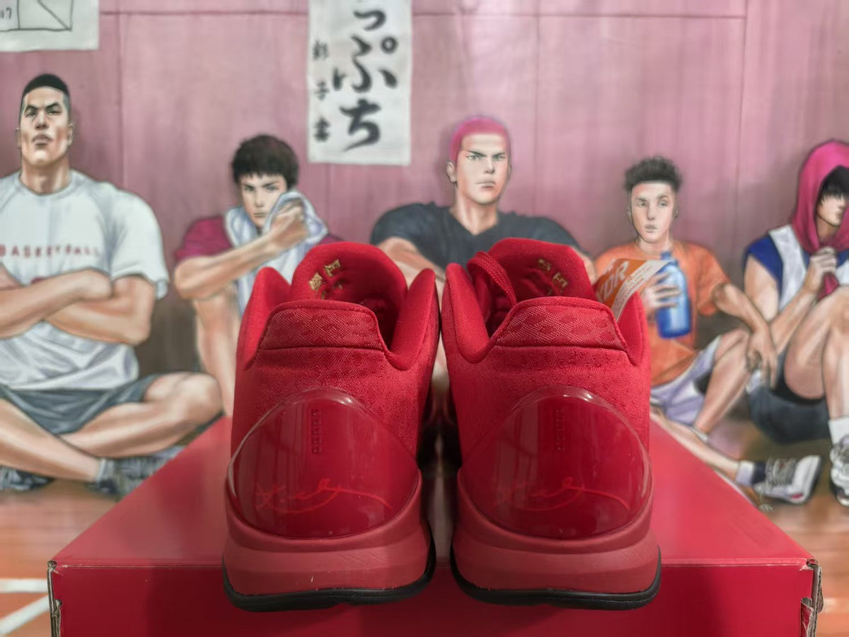 Rear view of a pair of red Nike basketball sneakers on a red shoebox, showing padded collars and translucent red heel panels.