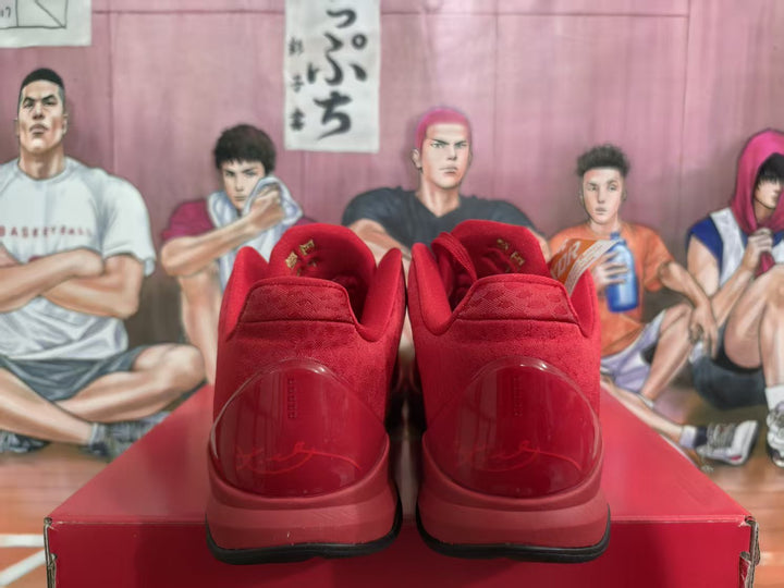 Rear view of a pair of red Nike basketball sneakers on a red shoebox, showing padded collars and translucent red heel panels.