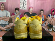 Rear view of matching yellow Nike basketball sneakers showing padded collars, heel branding and textured outsoles.