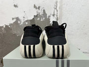 Rear view of black sneakers with white heel panels and ribbed details