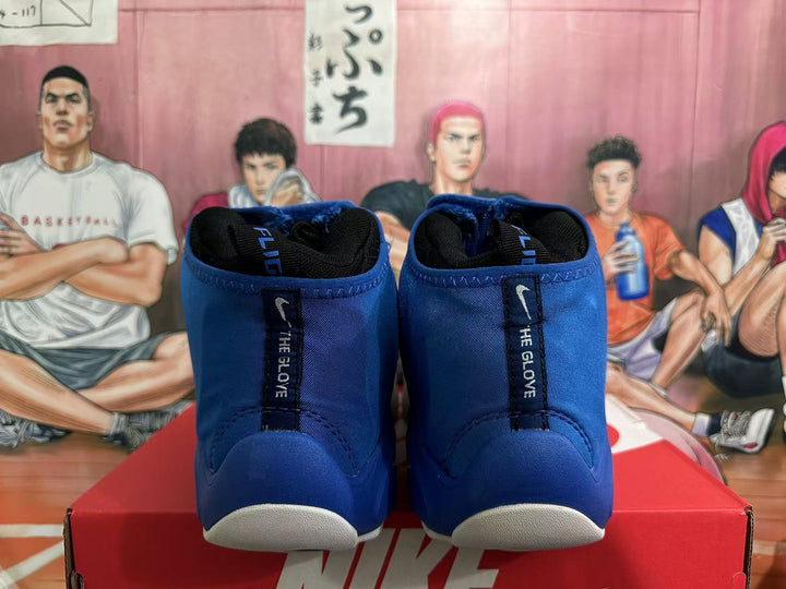 Rear view of blue high-top Nike basketball shoes with black heel tabs reading “THE GLOVE” and white sole accents.