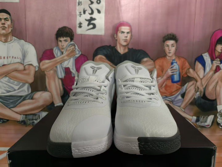 Front view of white and gray basketball sneakers showing the laces, tongue logos, textured uppers, and black outsole sections.