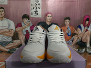 Front view of the white basketball sneakers showing white laces, perforated toe boxes, navy lining, and orange accents.