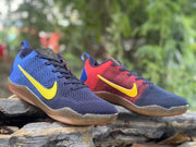 Close angled view of blue and red Kobe 11 sneakers with yellow Swooshes