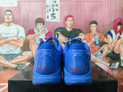 Rear view of blue basketball sneakers showing the heel construction and red signature-style graphics.