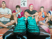 Front view of the teal lace-up sneakers showing the patterned toe boxes, teal laces, and black textured outsoles.