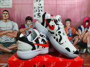 Angled view of the patterned Nike sneaker pair showing the white upper, black graphics, red Swoosh branding, and thick layered outsoles.