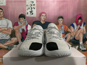 Front view of white basketball shoes with black toe accents and patterned laces