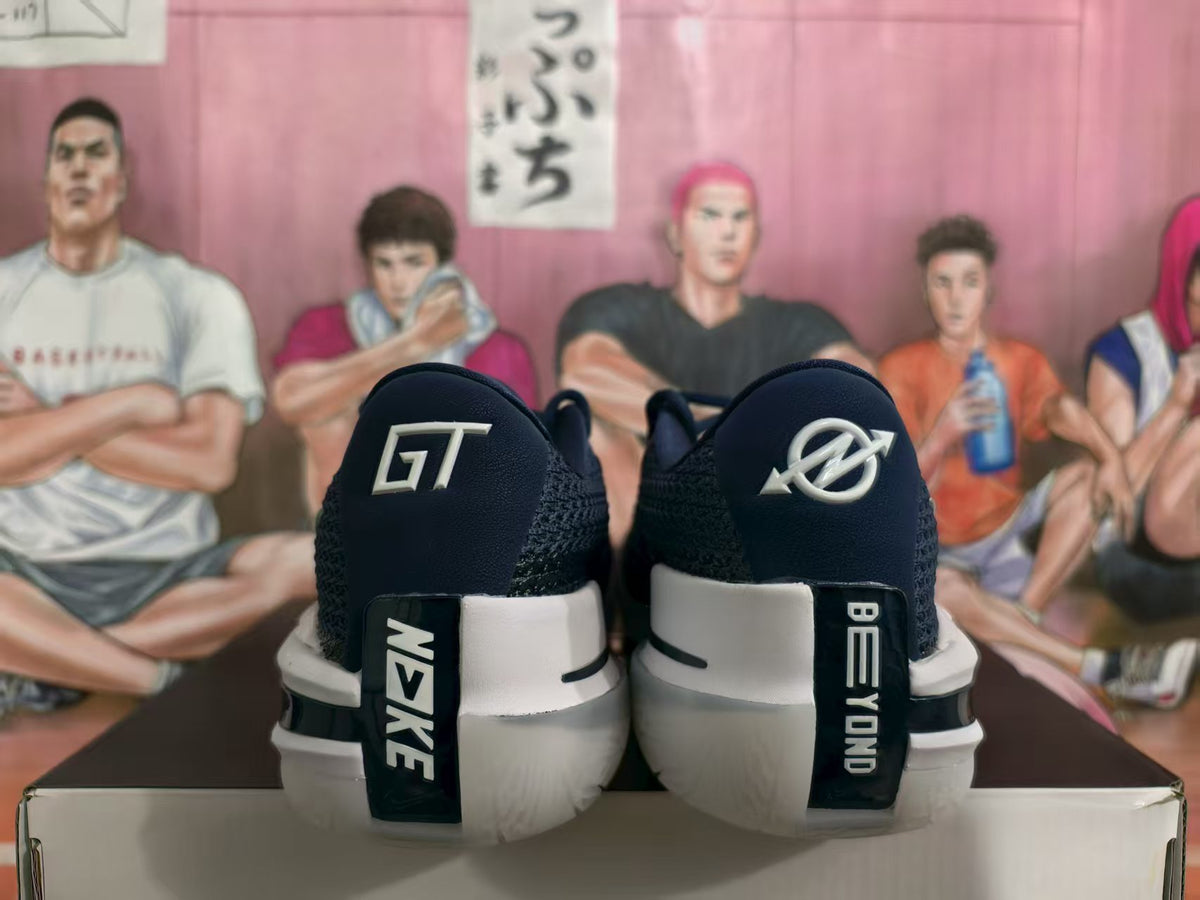 Rear view of navy and white Nike GT basketball sneakers showing contrasting heel markings and padded collars.