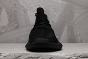 Front view of a black Yeezy 350 V2 sneaker showing the laces, knit upper, and rounded toe.