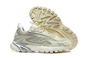 Beige and grey Louis Vuitton low-top sneakers shown from the side with one shoe turned to display the lugged outsole.