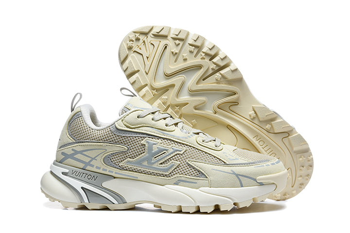 Beige and grey Louis Vuitton low-top sneakers shown from the side with one shoe turned to display the lugged outsole.