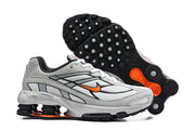 Nike Shox Ride 2 sneakers shown from the side and outsole, highlighting the black tread and orange details.