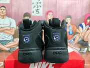 Rear view of black Nike high-top sneakers showing purple heel branding, DRC lettering, and pull tabs.