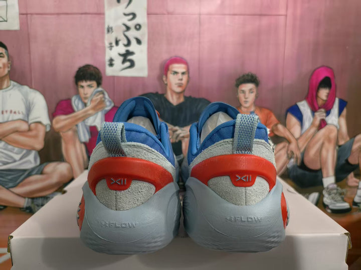 Rear view of blue sneakers with gray heel panels and red heel accents on a box.