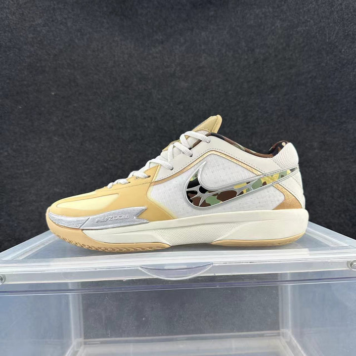 Low-top Nike basketball shoe in white and pale yellow, with a patterned side Swoosh and visible Zoom marking.