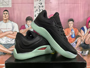 Angled view of the black basketball sneakers displaying the padded collar, laces and mint-green sole.