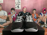 Front view of black basketball sneakers with white laces, textured uppers, and white toe sections.