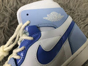 Close-up of the mist blue and white high-top sneaker showing the Swoosh, stitched overlays, laces, and winged basketball ankle logo.