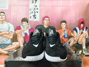 Front view of black lace-up basketball shoes with white details