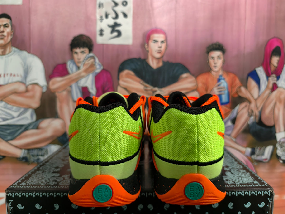 Rear view of fluorescent green Nike sneakers with orange heel accents, black trim, and teal outsole details on a patterned box.