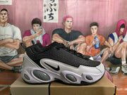 Side profile of a black, grey, and white Nike sneaker with a layered upper and sculpted sole.