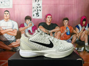 Side profile of a predominantly white basketball sneaker with textured panels and black side branding.