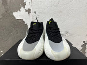 Front view of black lace-up basketball shoes with gray forefoot panels and neon-green tongue details.