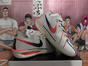 Angled view of the mismatched Nike basketball sneakers displaying contrasting side logos, perforated panels, and speckled midsoles.