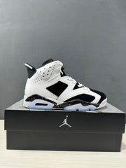 Side view of a white and black Jordan Air Jordan 6 high-top sneaker displayed on a black shoebox.