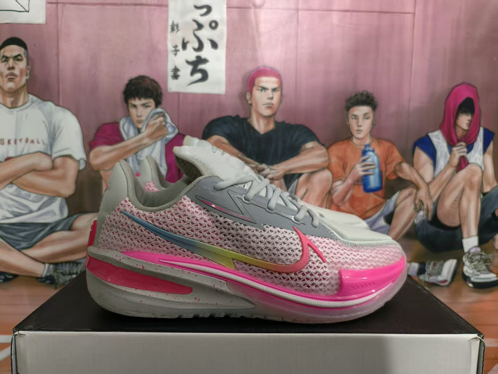 Gray and pink Nike GT basketball sneaker shown in side profile on a shoebox.