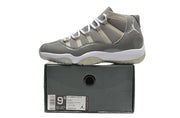 Side profile of one sneaker placed on a dark shoe box with a visible product label.