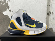 Side profile of a Nike Kobe 2K5 shoe with white, navy blue, and yellow panels.