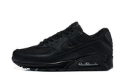 Side view of a black Nike Air Max 90 sneaker showing mesh panels, textured overlays, and the heel Air unit.