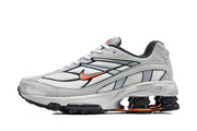 Side profile of a grey and white Nike Shox Ride 2 sneaker with orange accent and visible heel cushioning.