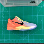 Side profile of the gradient basketball sneaker displayed on a green cutting mat, showing the textured upper and translucent outsole.