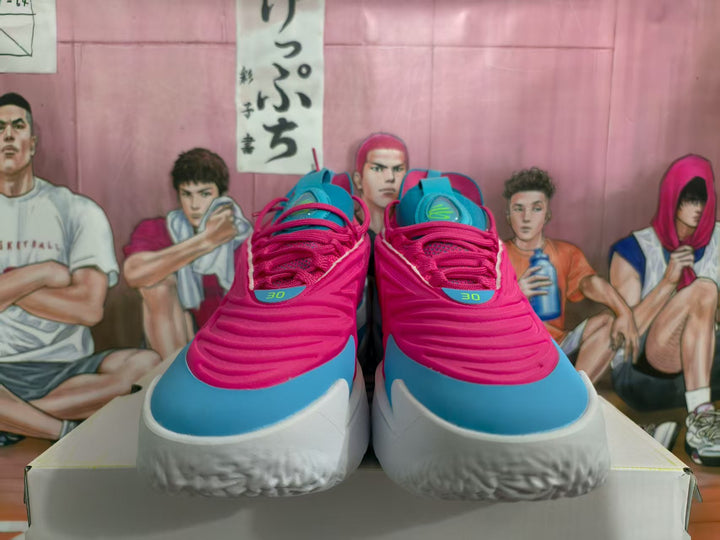 Front view of pink and blue sneakers with white midsoles displayed on a box.