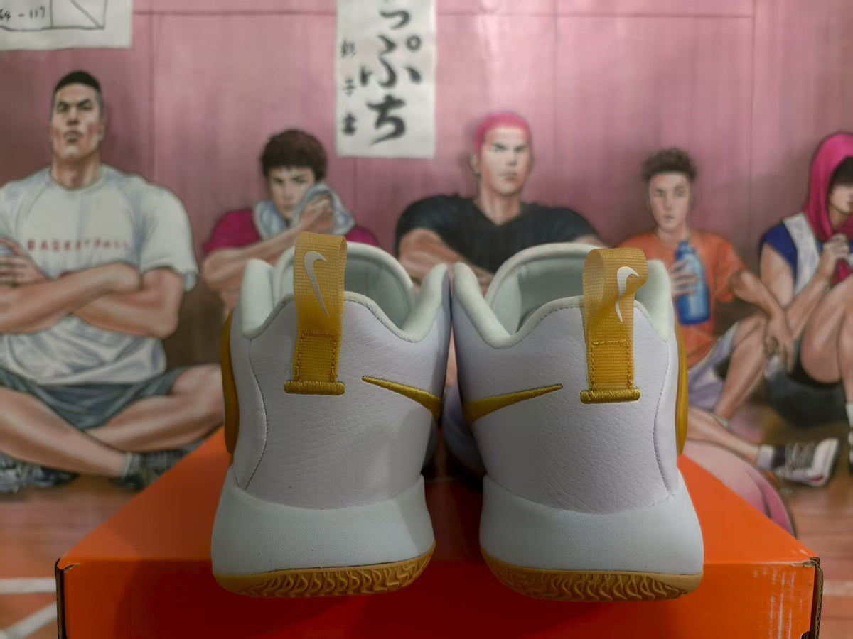 Rear view of white Nike basketball sneakers with yellow-gold heel tabs, Swoosh details, and gum-colored outsoles.