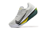 Angled side view of a white Nike Zoom Fly 6 shoe with dark green and yellow sole accents.