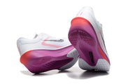 Rear and outsole views of white Nike Zoom Fly 6 shoes with magenta and coral accents.