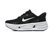 Side view of a black Nike Comfort Ride EasyOn sneaker with a white Swoosh and thick white midsole.