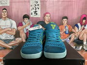 Front view showing the blue textured uppers, blue laces, green accents and pale outsoles.