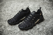 Pair of black and gold Nike TN-11 sneakers viewed from above